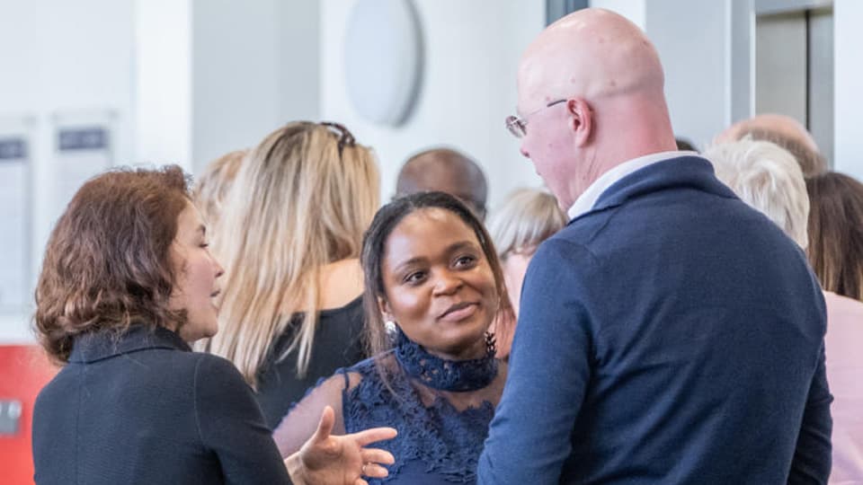 Academics conversing in the Business School hub.